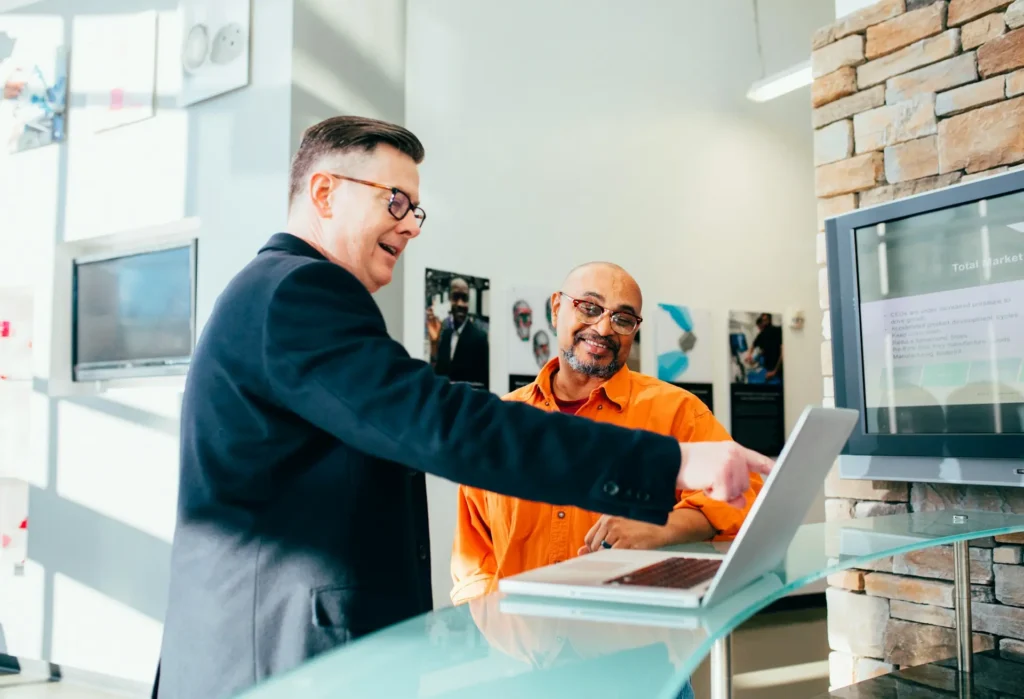 Accountant discussing something on laptop screen with client